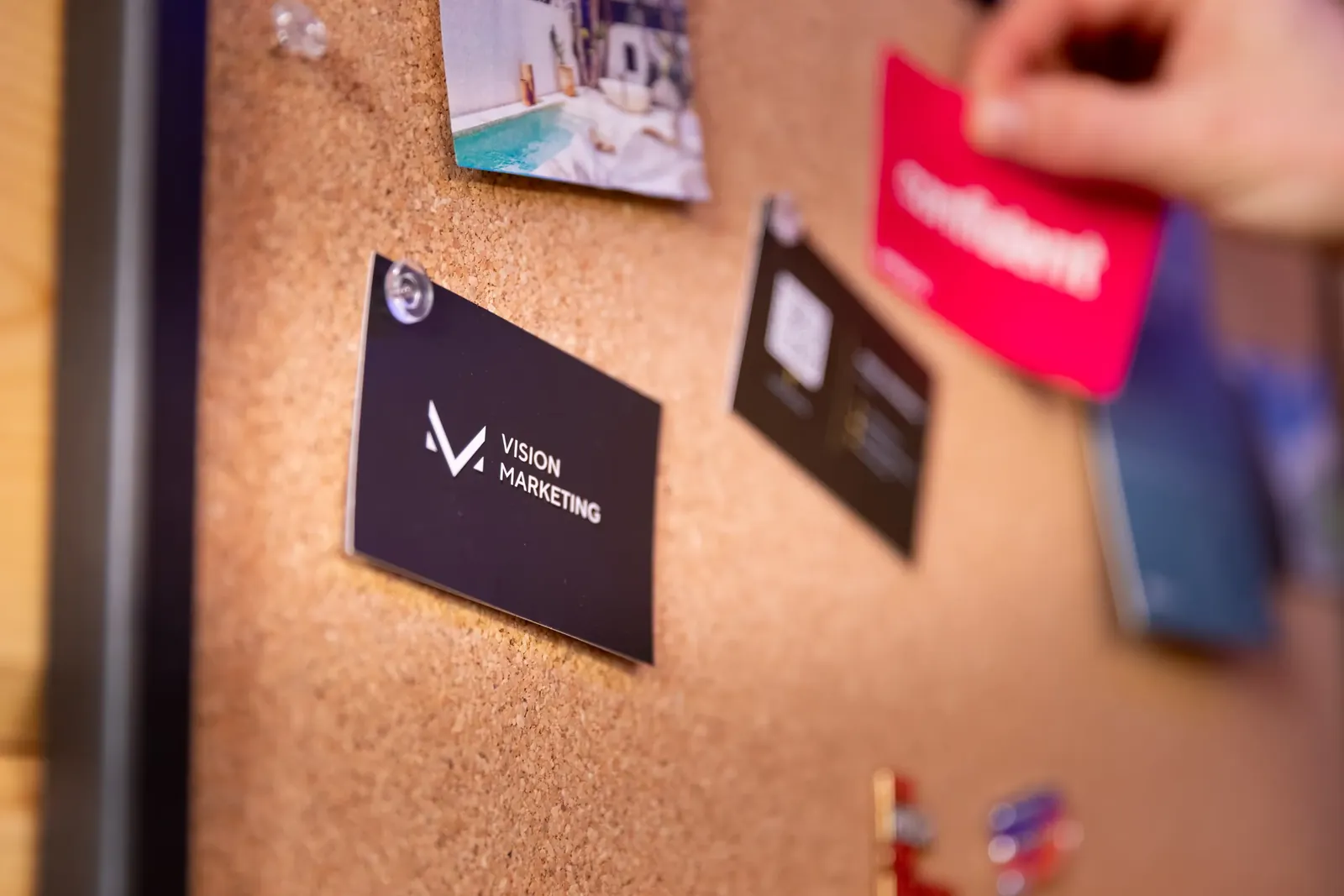 Vision Marketing business cards pinned to the studio corkboard